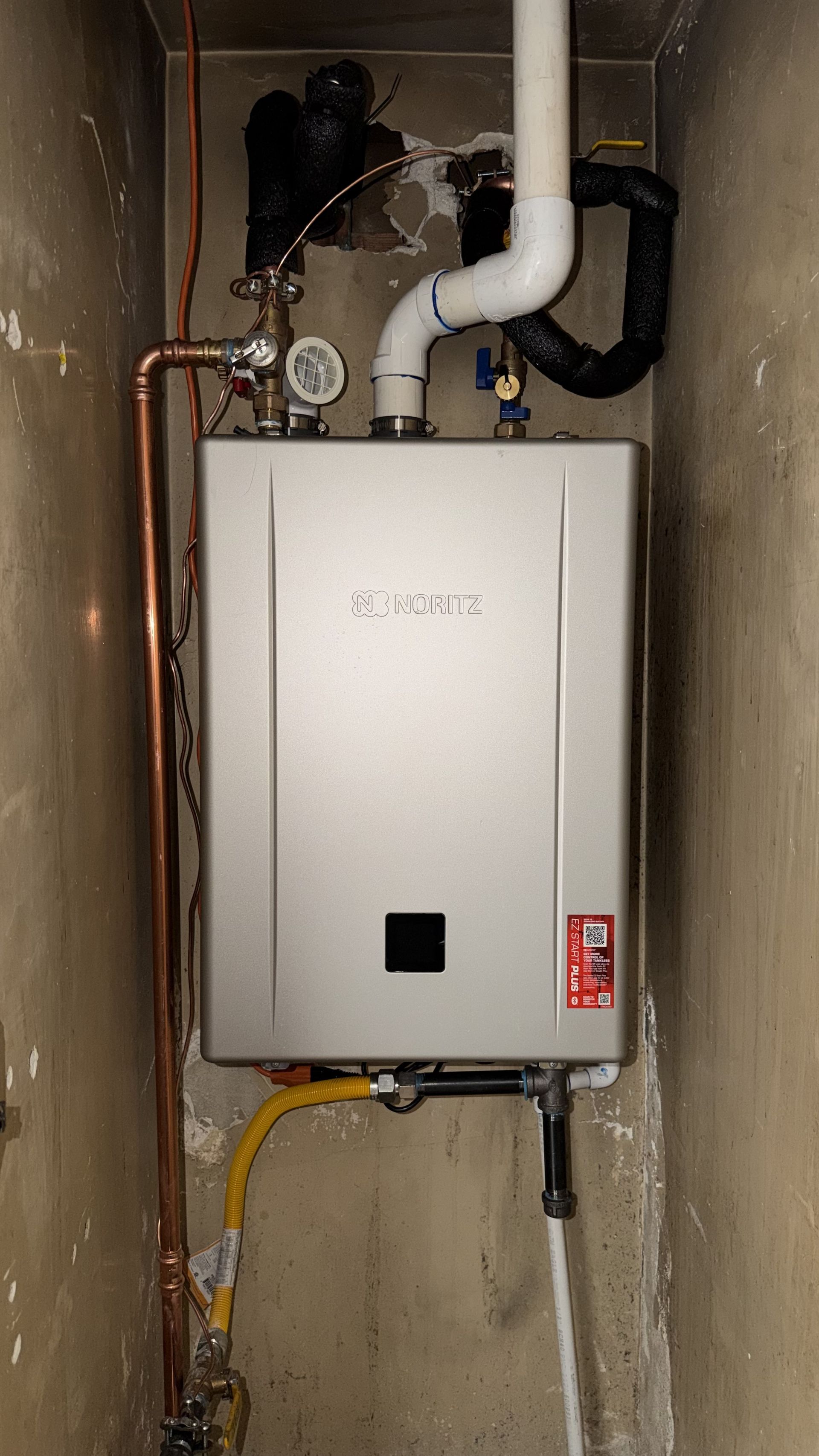 JJJ Plumbing technician installing a Noritz tankless water heater